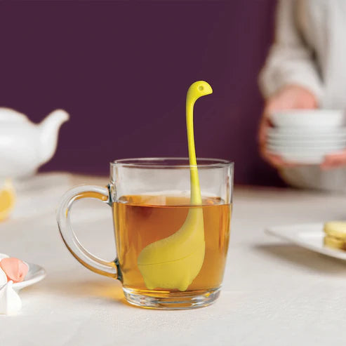 Yellow rubber duckling in a glass of tea on a table with a blurred background