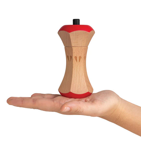 Wooden pepper grinder with red accents held in a hand on a white background